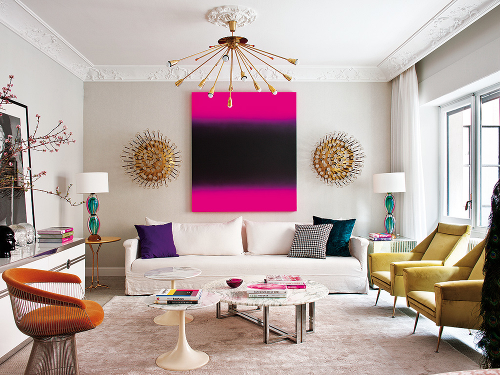 A living room with a large painting on the wall, featuring Mid-Century Modern Glamour.