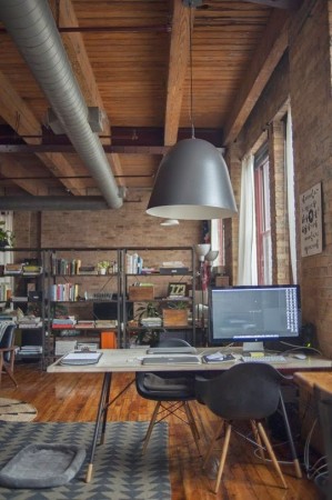 An industrial style home office with a desk and chairs.