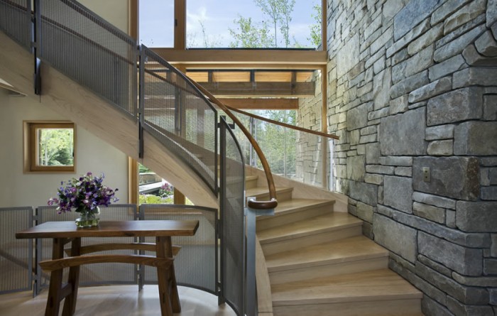 A modern home with stone walls and a staircase.