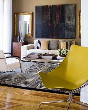 Using abstract art to enhance your living room with a vibrant yellow chair.