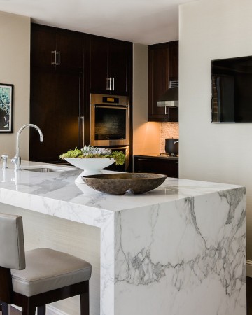 A kitchen with a waterfall marble countertop.