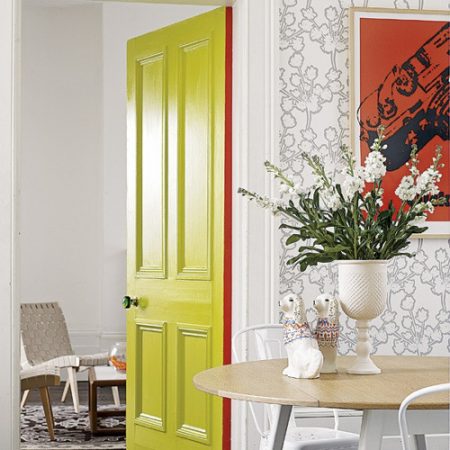 A unique interior door idea featuring a bright yellow door in a dining room.