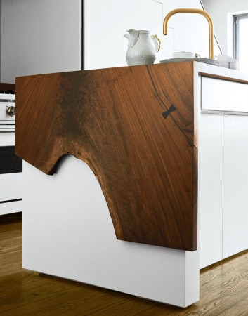 A wooden top kitchen island with waterfall countertops.