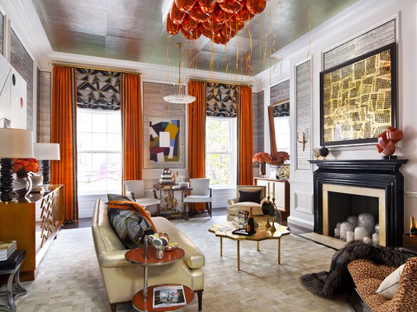 A living room with orange curtains and a fireplace featured in 20 Designer Showhouse Rooms to Spark Your Inner Decorator.