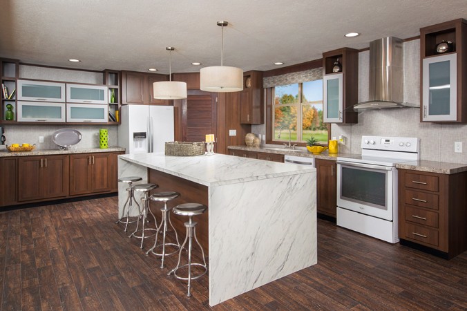 A kitchen with white cabinets and a marble waterfall counter top.