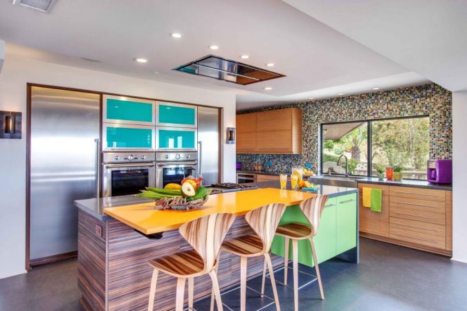 A modern kitchen with colorful counter tops.