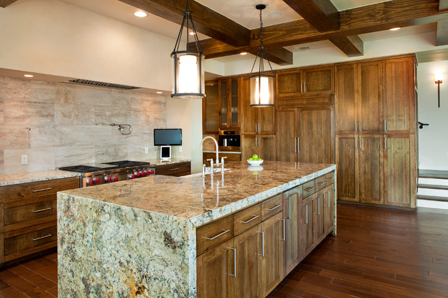 A kitchen with wood cabinets and granite counter tops featuring waterfall kitchen countertops.
