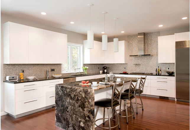 A modern kitchen with sleek marble counter tops and stylish stools.