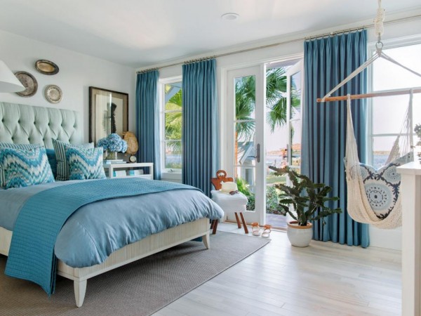 A serene coastal bedroom with a hammock hanging from the ceiling.