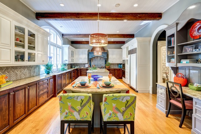 A kitchen with a center island and chairs showcasing 20 Designer Showhouse Rooms to Spark Your Inner Decorator.