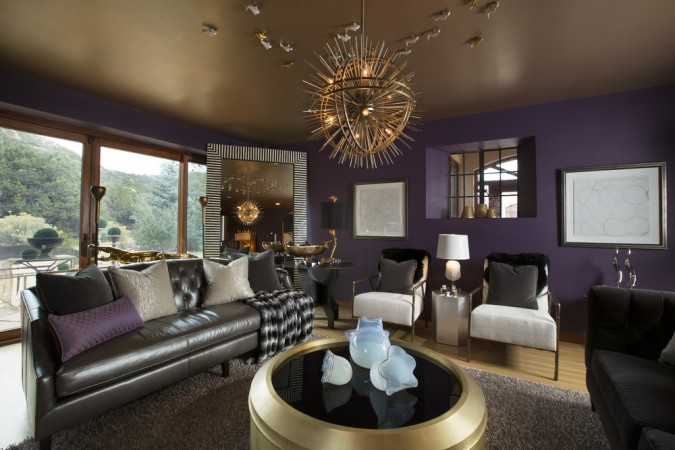 A living room with purple walls and a gold chandelier featured in 20 Designer Showhouse Rooms to Spark Your Inner Decorator.