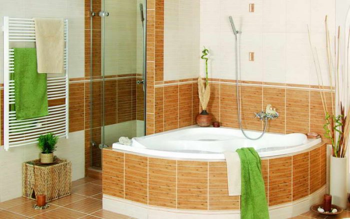 Learn how to redecorate your bathroom with brown tile and green towels on a budget.