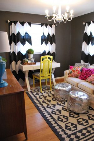 An eclectic living room with chevron striped curtains.