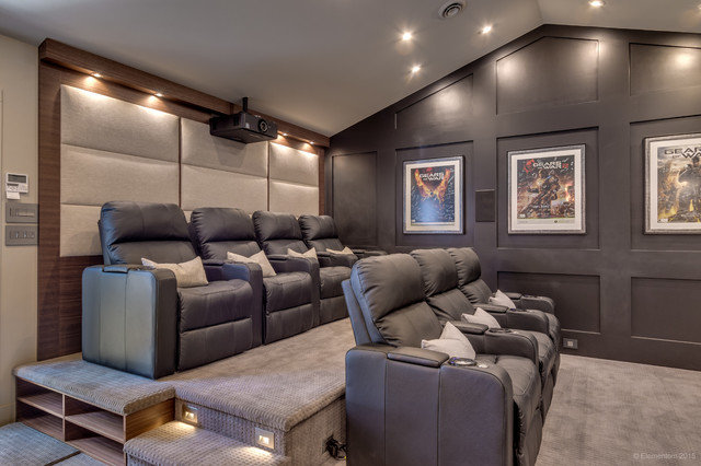 A home theater room converted from a garage, equipped with a large screen and reclining seats.