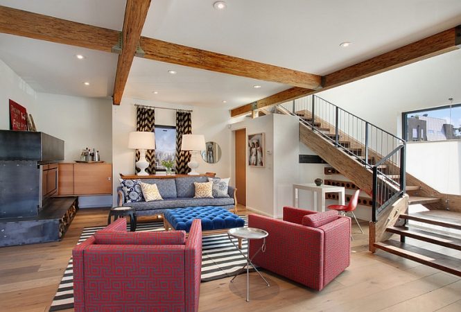 A living room with a statement fireplace and wooden beams.