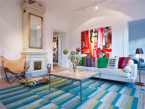 A living room with a colorful rug and a painting on the wall is a statement.