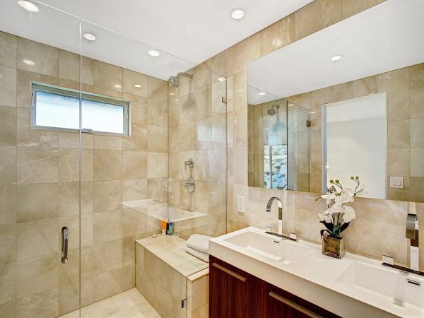 A beautiful bathroom with two sinks and a glass shower featuring stunning tile ideas.