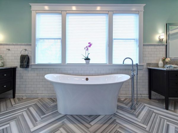 A bathroom with a beautiful chevron tile floor.