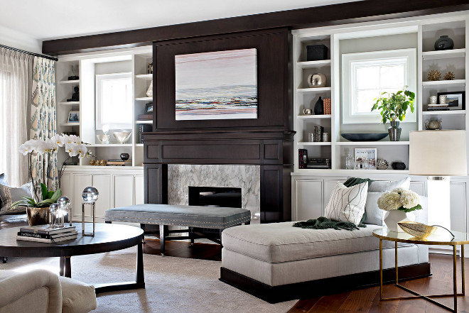 A family room with a fireplace and bookshelves.