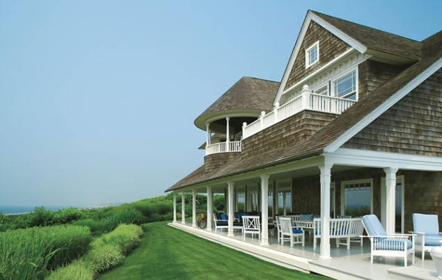 A Cape Cod beach house with lawn chairs.