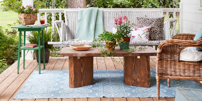 A wicker chair and table on a porch, providing patio ideas.