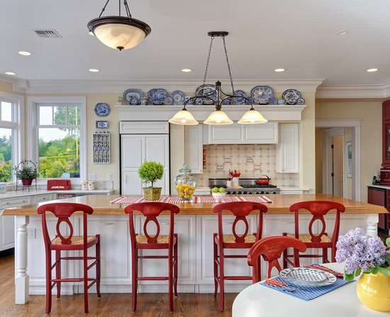 A kitchen with red chairs and a center island.