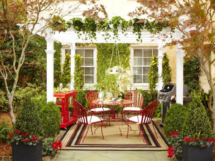 Patio ideas with a pergola and red chairs.