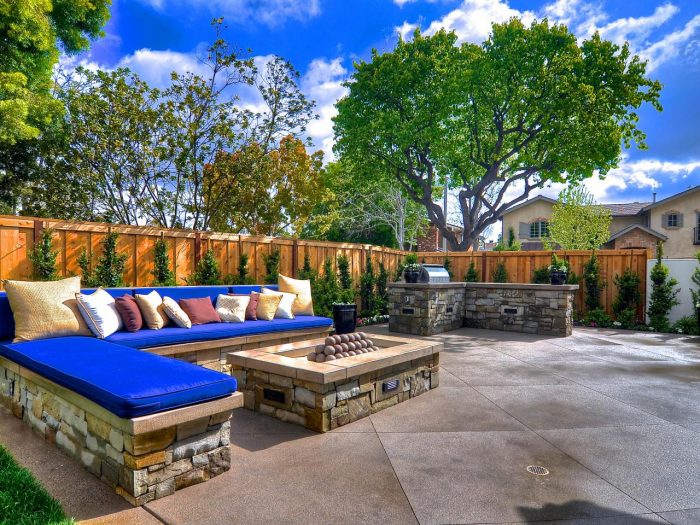 A patio with a blue couch and a fire pit.