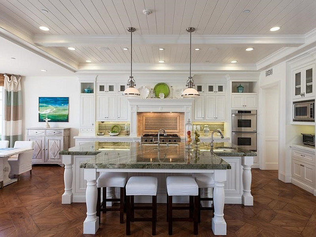 A Cape Cod-inspired white kitchen with a center island and bar stools.