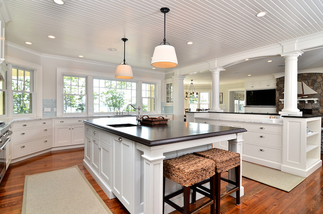 A large kitchen with white cabinets and a center island, inspired by Cape Cod.
