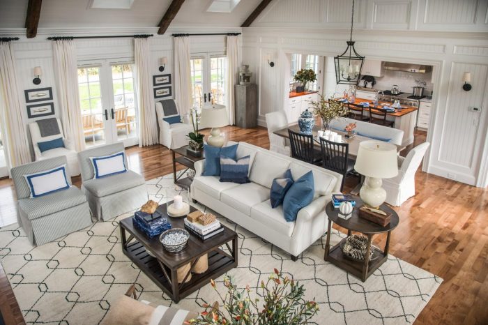 An aerial view of a living room with white furniture and blue accents.