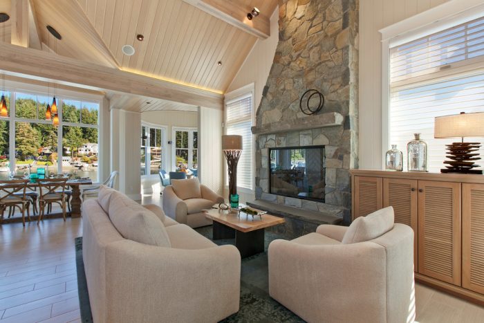 A large living room with a stone fireplace in Cape Cod.