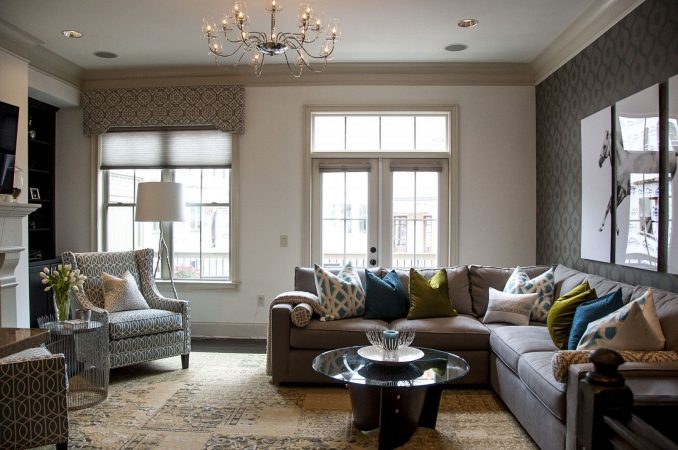 A living room with gray and cream furniture and a fireplace.