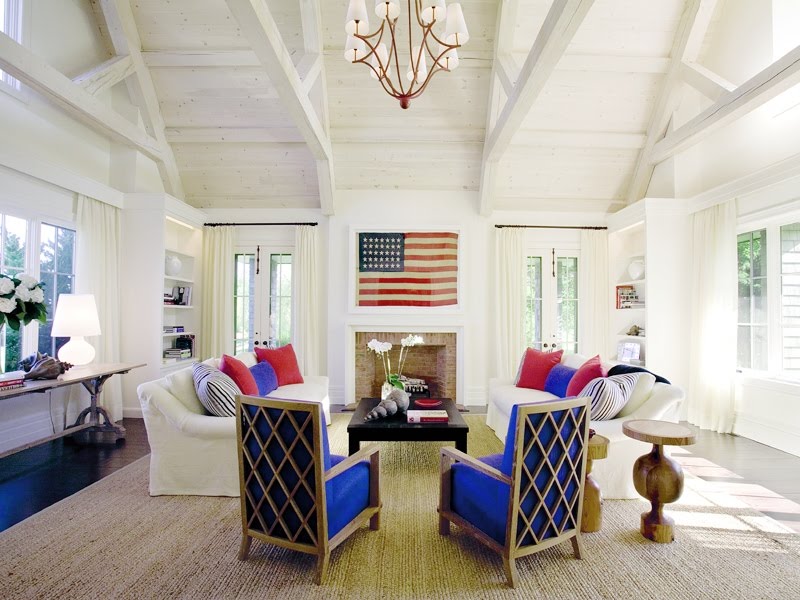 A white living room with a red American flag on the wall.