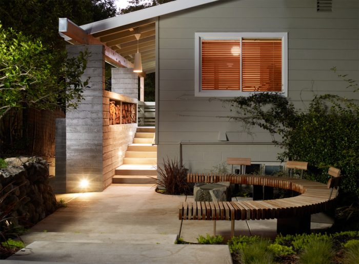 A wooden bench in front of a house, perfect for patio ideas.