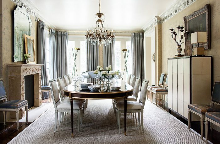 A formal dining room with gray chairs and a chandelier.