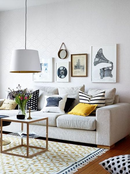 A stylish living room with a white couch and yellow polka dot rug.