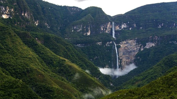 A waterfall in the middle of a lush green valley in Peru.