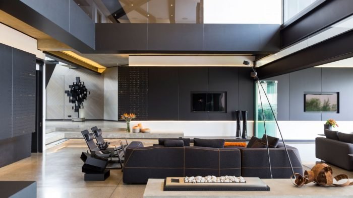 The Kloff Road House features a modern living room with black walls and furniture.