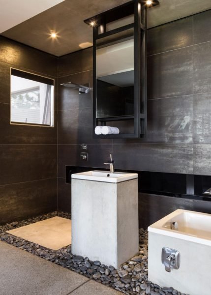 A modern bathroom with black walls and a sink at Kloff Road House.