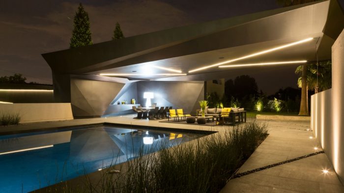 A modern Kloff Road House backyard with a pool at night.