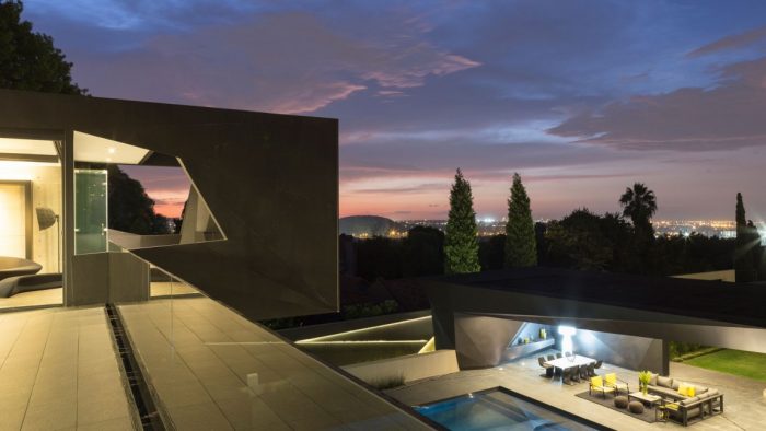 A modern house on Kloff Road with a swimming pool at dusk.