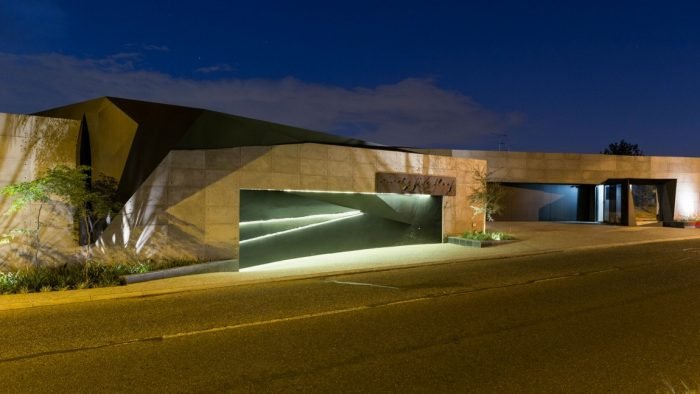 Kloff Road House - A modern house with a concrete facade at night.