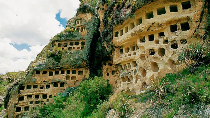 A rocky cliff with numerous caves located in Peru.