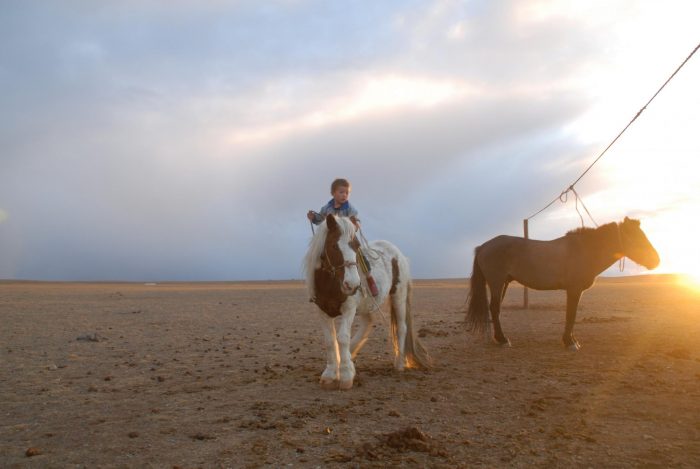 A boy riding a horse in Mongolia.