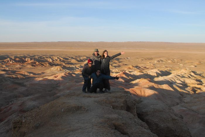 Four people posing on the flaming cliffs in the Gobi desert, mongolia experiences, 