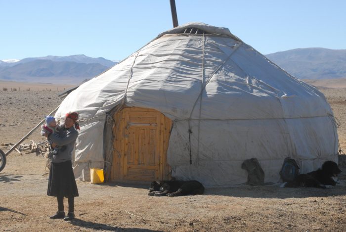 Woman and baby outside ger in desert, Mongolia