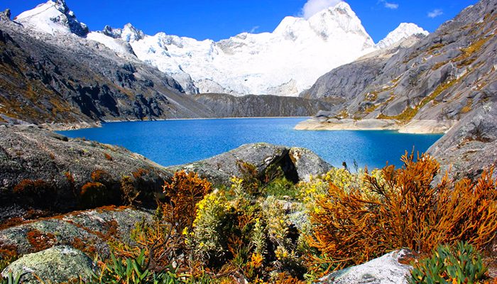 A blue lake surrounded by mountains and bushes in Peru.