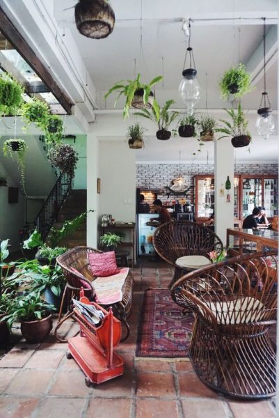 A cozy living room decorated with wicker chairs and hanging plants.