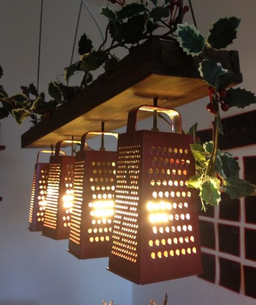 An upcycled light fixture with graters hanging from it.